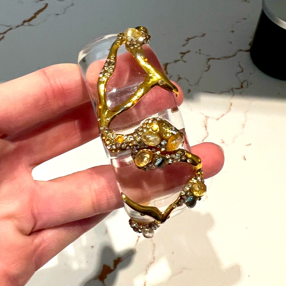 Alexis Bitter lucite cuff with gold river and stones throughout.